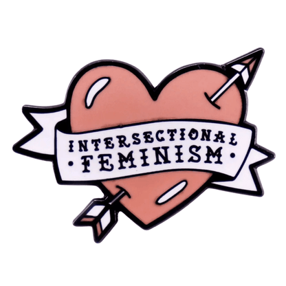 Red enamel heart pin pierced by an arrow, featuring a white ribbon with “Intersectional Feminism” in bold black—perfect for wearing alongside your favorite rainbow pride pin.