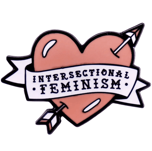 A pink love heart enamel pin from My Cutesy Era features an arrow, white banner reading Intersectional Feminism, and a bold, outlined design—ideal for any feminist enamel pin collection.