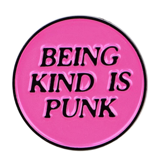 A round, pink and black enamel pin with bold BEING KIND IS PUNK text—perfect for adding to your pride collection.