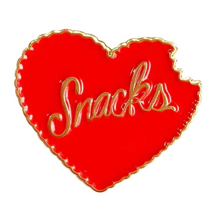 A sassy red love heart badge  with a gold border and Snacks in gold script. The red heart has a bite mark on the upper right. Ships worldwide!.