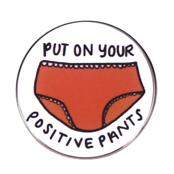 Button badge with red underwear illustration and text 'Put on your positive pants' on a white background