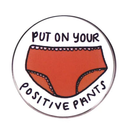 Button badge with red underwear illustration and text 'Put on your positive pants' on a white background