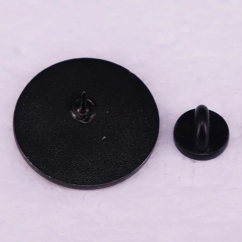 A black circular Introvert enamel pin by Gay Skate, with matching backing, is displayed on a light textured surface—a perfect pride accessory for those who embrace quiet confidence.