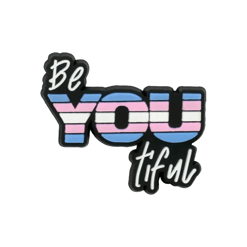 The image features BeYOUtiful design, with “YOU” in uppercase striped in pink, blue, and white like the Trans Flag—celebrating individuality and pride.