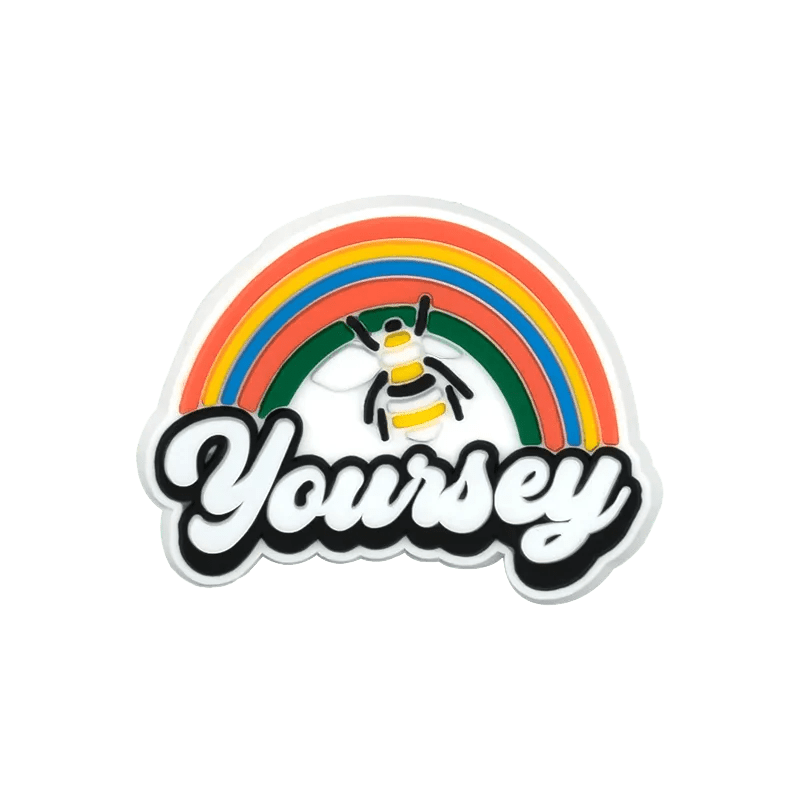 A vibrant Kiss Me Later pin features a rainbow, a bee, and “Yoursey” in bold cursive. With playful pride charm and cheerful vibes, it’s the perfect accessory to show your support in style.