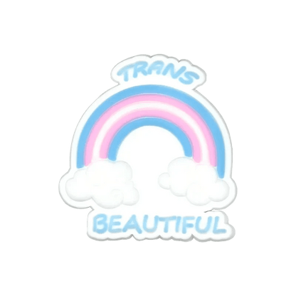 A pastel rainbow in blue, pink, and white—echoing the Trans Flag—arches over two clouds. Above is TRANS and below is BEAUTIFUL, both in blue letters. Designed by Kiss Me Later.