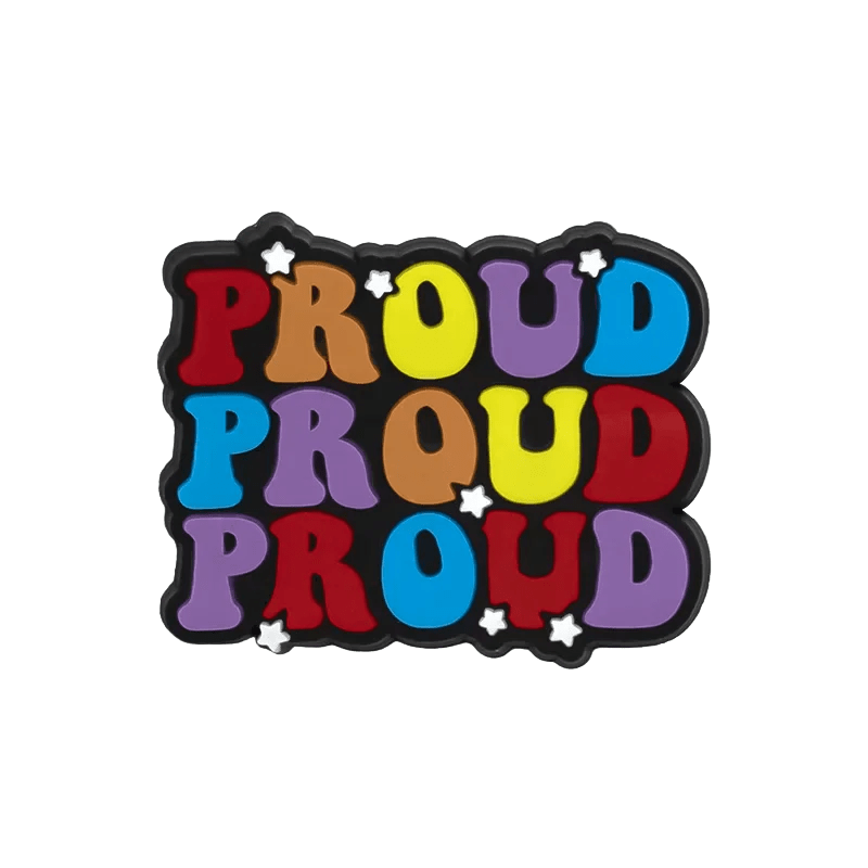 From Kiss Me Later: Vibrant graphic featuring PROUD repeated in bold, playful, multi-colored letters with white stars and pride charms inspired by the Trans and Rainbow Flags, set on a transparent background.