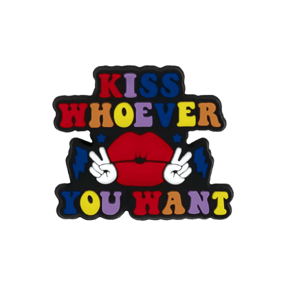 A colorful Kiss Me Later graphic shows Kiss Whoever You Want above and below red lips, two peace sign hands, pride charms, blue lightning bolts, all set on a black background.