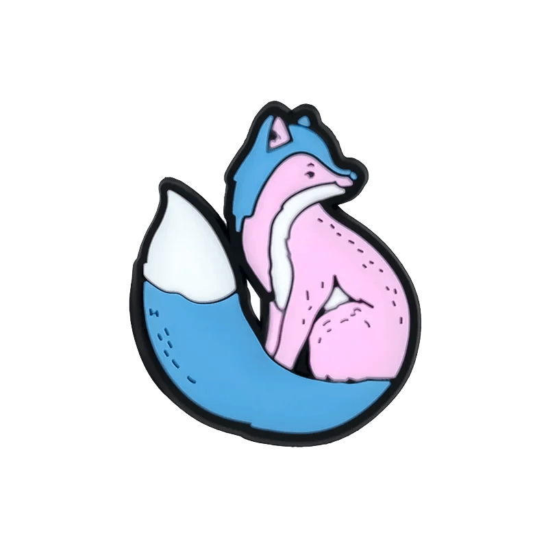 Kiss Me Later’s stylized fox illustration features a blue tail and head, pink body, and bold black outline—cartoon charm inspired by the Trans Flag, perfect for showing pride flair or adding to your charms.