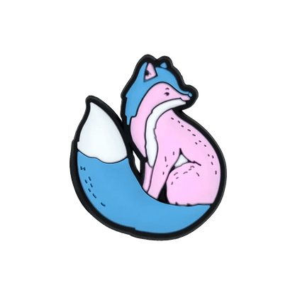A stylized Kiss Me Later fox sits with blue and pink Trans Flag-inspired fur, a large bushy blue tail tipped in white, and bold black outlines on a transparent background.