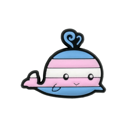 A Kiss Me Later cartoon whale features a smiling face and horizontal blue, pink, and white stripes like the Trans Flag, completed with matching pride charm water spout.
