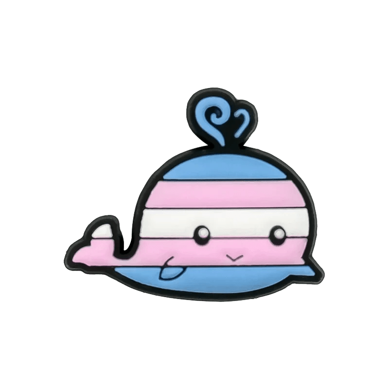 A cute cartoon whale in light blue, pink, and white stripes, inspired by the Trans Flag, smiles with a water spout—an adorable Kiss Me Later charm to enhance your pride collection.