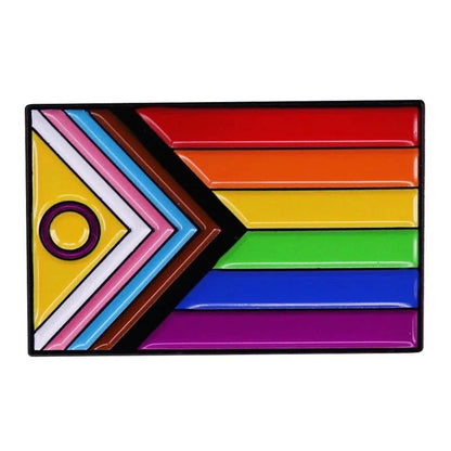 A rectangular flag with horizontal rainbow stripes, a chevron of white, pink, blue, brown, and black on the left, plus a yellow triangle with a purple circle. This inclusive Progress Pride Flag decorates Gay Skates rainbow pride pins.