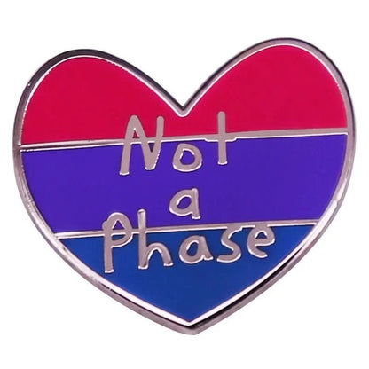 heart-shaped pin displays the bisexual pride flag—pink, purple, and blue stripes—and features Not a Phase in silver lettering across the center.