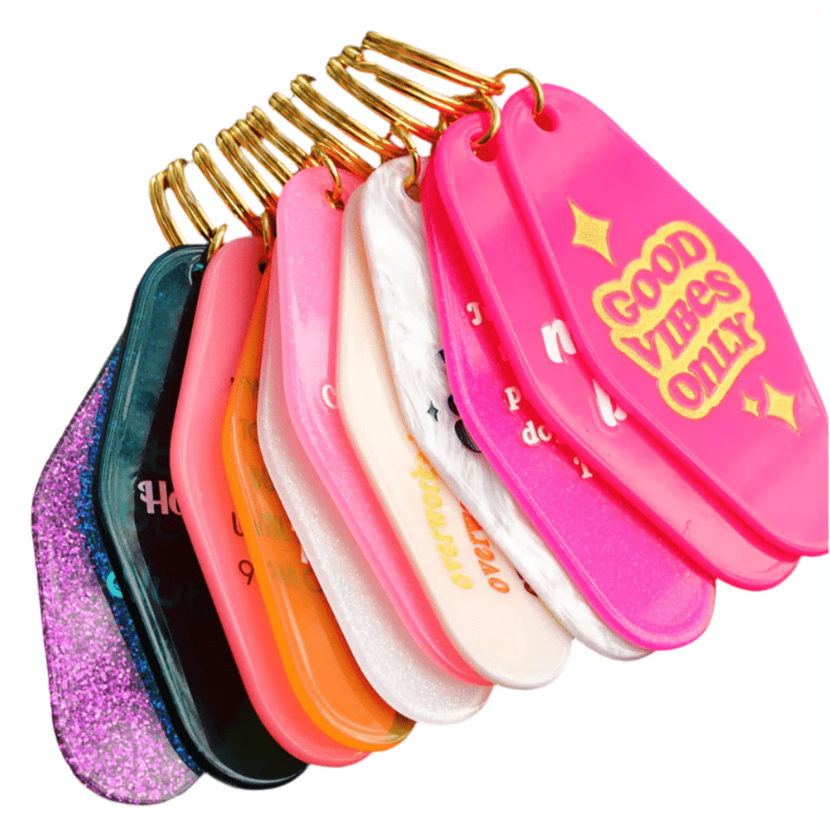 A set of colorful, retro-style hotel key rings features 12cm gold rings. The front bright pink keychain reads “GOOD VIBES ONLY” in yellow, with others in assorted designs. Worldwide shipping available.