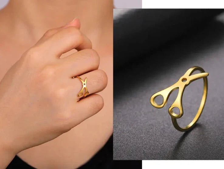 Scissor Ring, crafted from gold-toned stainless steel, is shown on a finger and in close-up on a dark surface—a bold accessory for any sapphic pride collection.