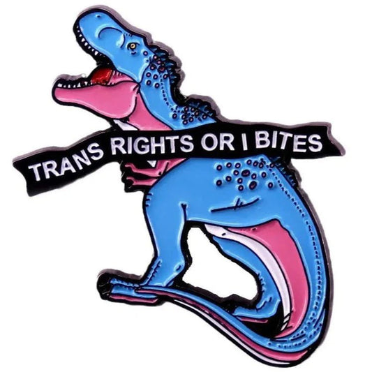 Enamel pin featuring a cartoon blue and pink dinosaur (trans pride colors) with its mouth open and TRANS RIGHTS OR I BITES boldly across its body.