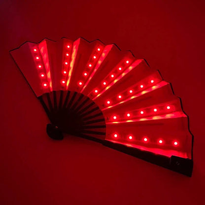 The My Cutesy Era rechargeable LED fan glows with bright red lights, evenly spaced along each open panel, against a dark red background.