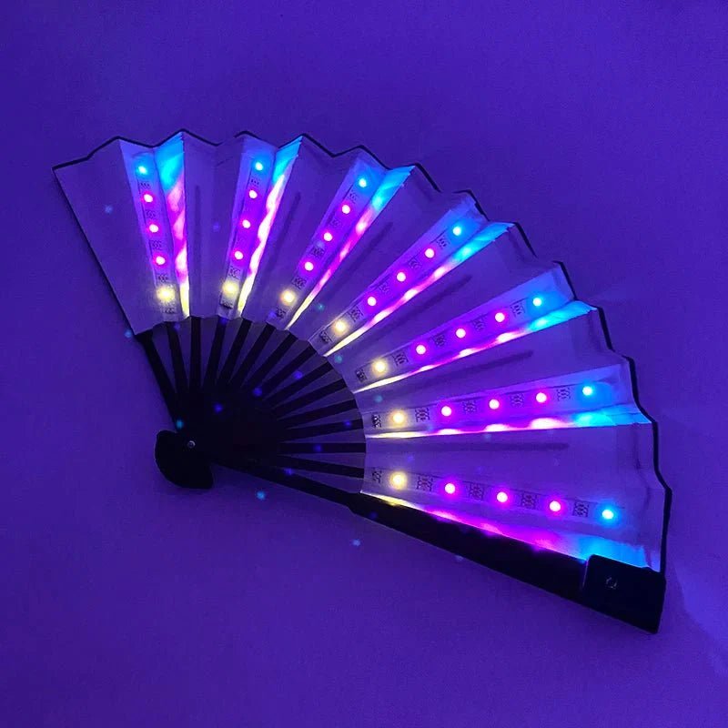 The My Cutesy Era handheld folding fan features transparent blades illuminated by blue, purple, and pink LEDs, glowing brightly against a dark purple backdrop—a stylish battery-powered fan ideal for night events.
