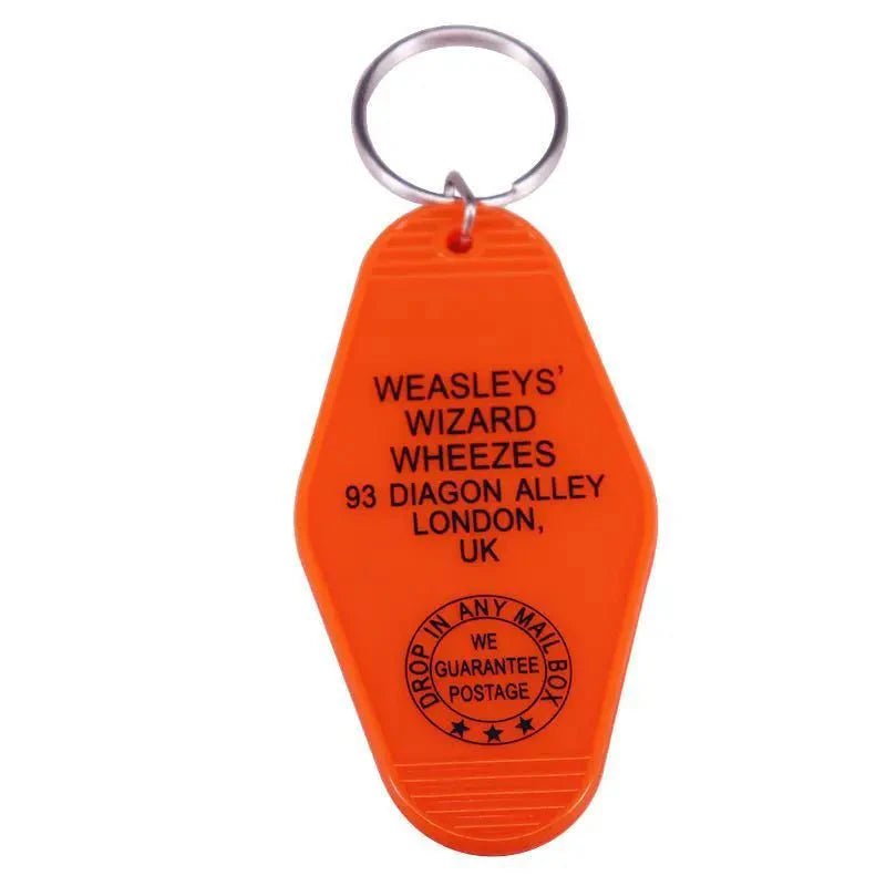 An orange retro hotel key ring by Kiss Me Later, shaped like a vintage motel fob and printed with Weasleys Wizard Wheezes, 93 Diagon Alley, London, UK plus a stamp: Drop in any mail box. We guarantee postage.