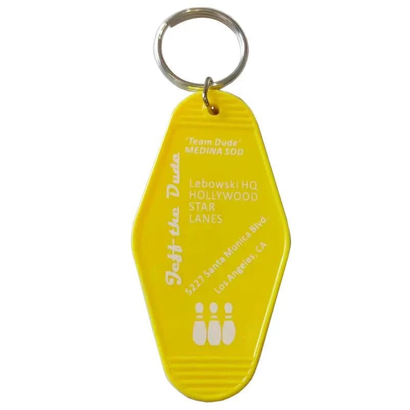 The Kiss Me Later yellow retro hotel key ring features white text inspired by The Big Lebowski, with Lebowski HQ, Hollywood Star Lanes, 5227 Santa Monica Blvd, Los Angeles, CA, and three bowling pin graphics—a must-have accessory.