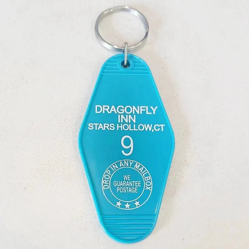 The Kiss Me Later blue retro hotel key ring features Dragonfly Inn, Stars Hollow, CT, 9 and a Drop in any mailbox circle. This pop culture accessory has a silver keyring and vintage charm—perfect for colorful key ring fans.