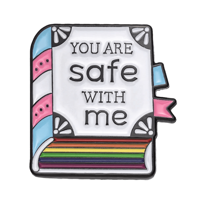 Show your pride with this Kiss Me Later enamel pin—a book featuring trans pride pastel blue, pink, and white stripes on the spine, rainbow-colored pages, and the text You are safe with me. Perfect for any accessory collection!.