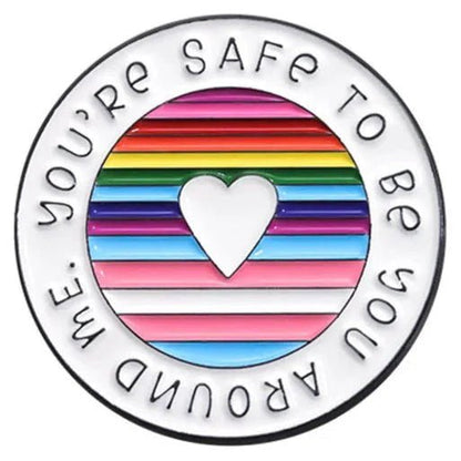 Show your pride with round pastel rainbow heart pin—etched with “You’re safe to be you around me.” LGBTIQ+SB ally accessory, heart cutout, and worldwide shipping for all!.