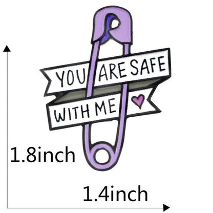 Gay Skate enamel badge featuring a purple safety pin love heart with banners saying YOU ARE SAFE WITH ME and a pink heart. Measures 1.8 tall by 1.4 wide—perfect pride accessory or supportive gift.
