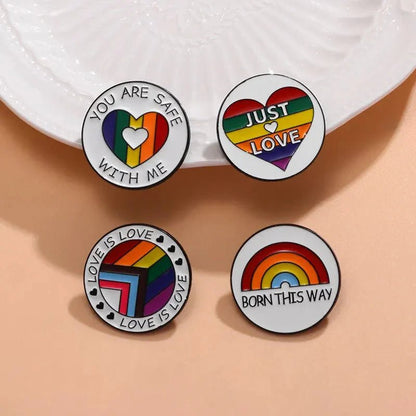 set of four rainbow pride enamel pins spreads LGBTQ+ love with messages like YOU ARE SAFE WITH ME, JUST LOVE, LOVE IS LOVE, and BORN THIS WAY. Show your support—worldwide shipping available!.